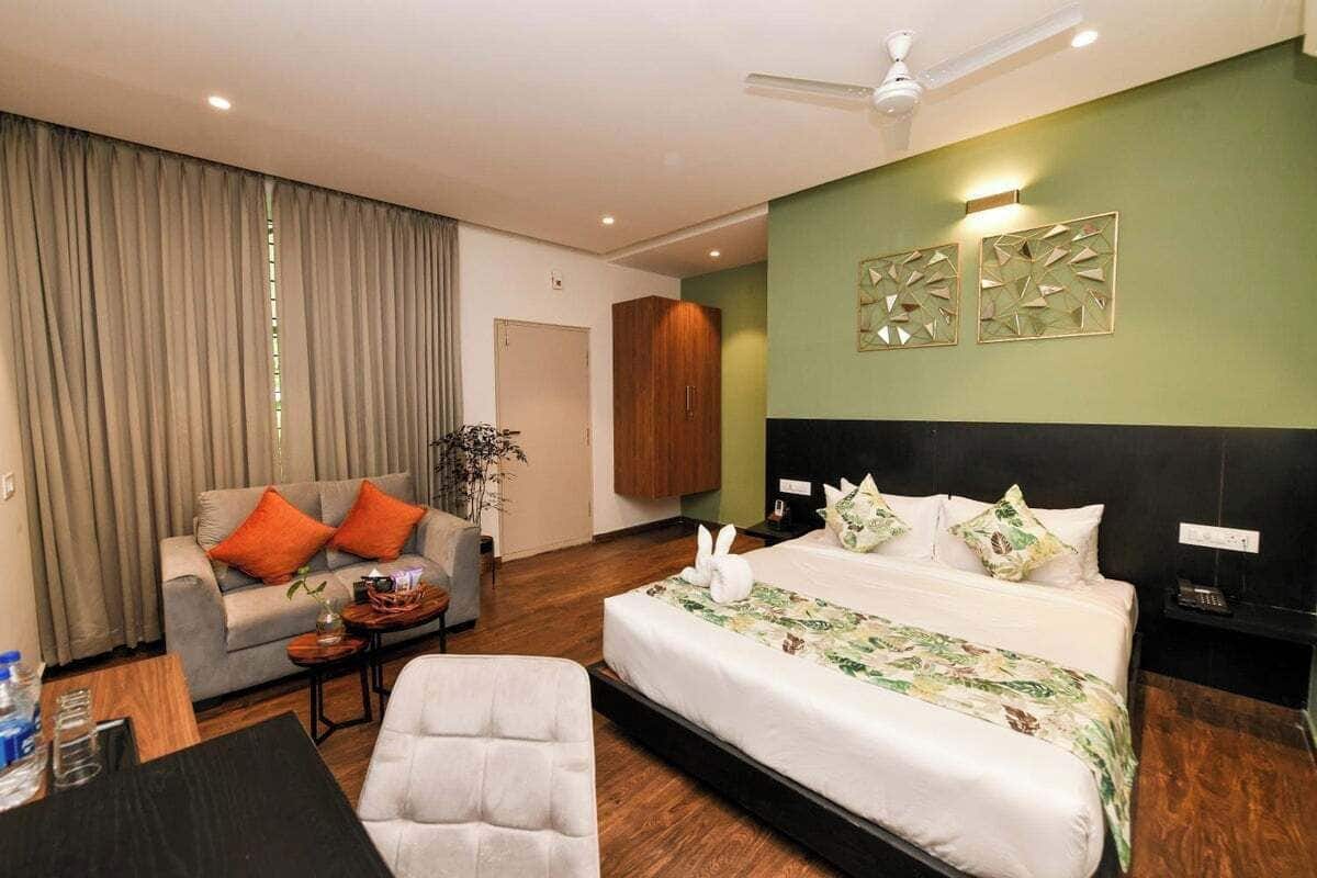 Ein Hotelzimmer mit einem großen Bett, einer Couch, einem Esstisch und einem Deckenventilator.