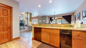A spacious kitchen with wooden cabinets, granite countertops, and a built-in dishwasher.