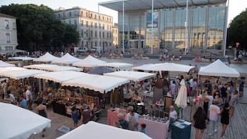 Un mercado al aire libre animado con varias carpas blancas y gente comprando.