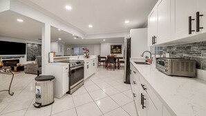 A modern kitchen with white cabinets, a built-in oven, and a microwave. - Boca Raton Home: Outdoor Kitchen, By Golf Courses (Boca Raton)