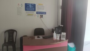 Ein Empfangsschalter mit Computer, Stuhl und einem G Pay QR-Code.