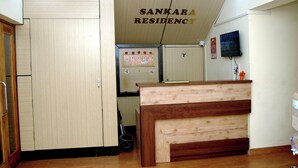 A reception desk with a wooden finish, a ceiling fan, and a sign reading "SANKARA RESIDENCY". - SANKARA RESIDENCY (Kanchipuram)