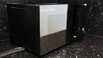 A black microwave with the brand name "Russell Hobbs" on the front.