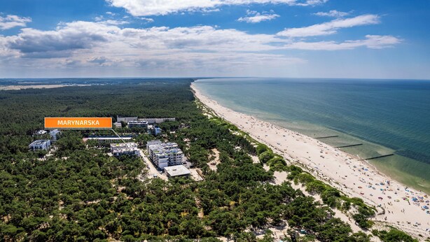 Luftaufnahme einer Küstenlandschaft mit Strand, dichtem Wald und einem gekennzeichneten Gebiet namens "MARYNAPRSKA".
