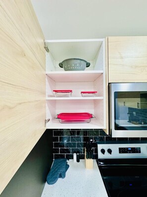 Una cocina con armarios de madera, un microondas y una estufa.