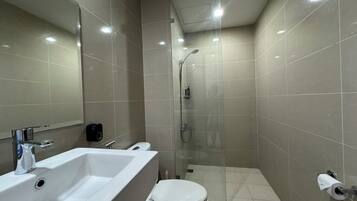 A bathroom with a white sink, toilet, and shower.