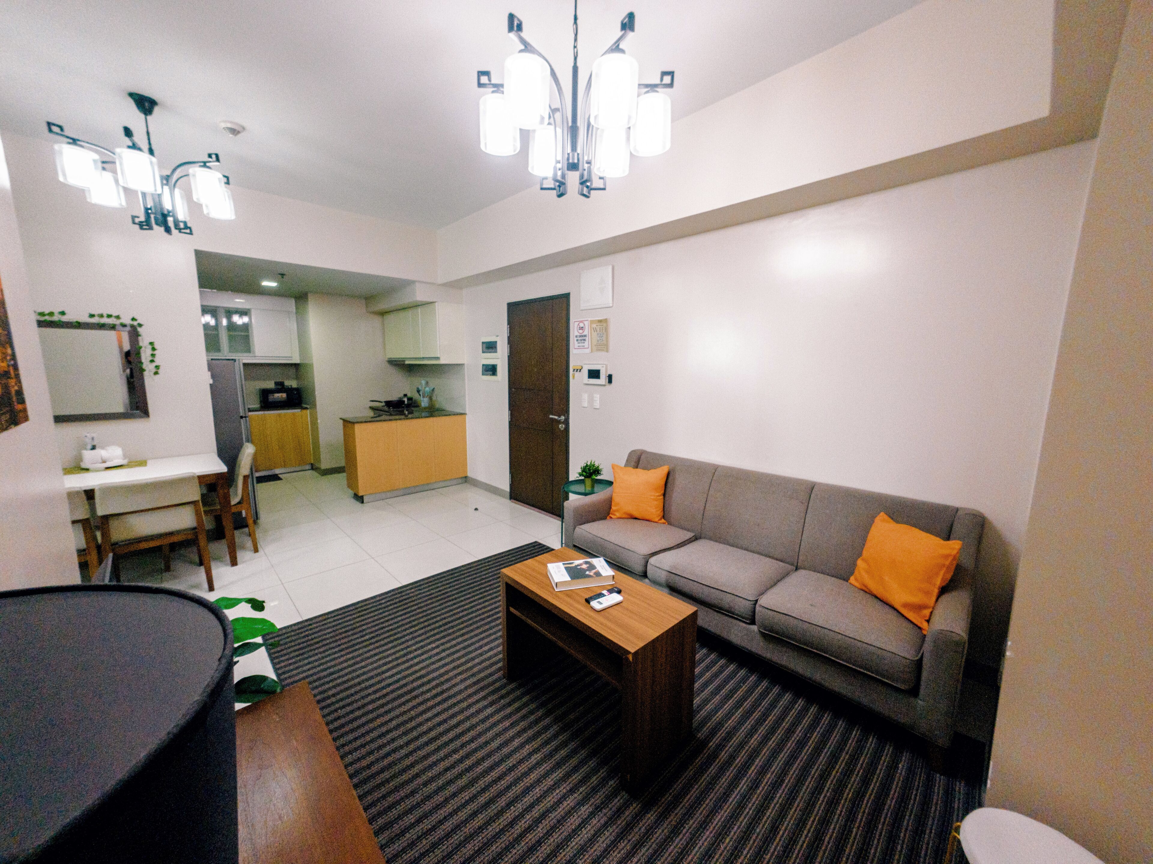 A living room with a sofa, coffee table, and a dining area with a table and chairs.
