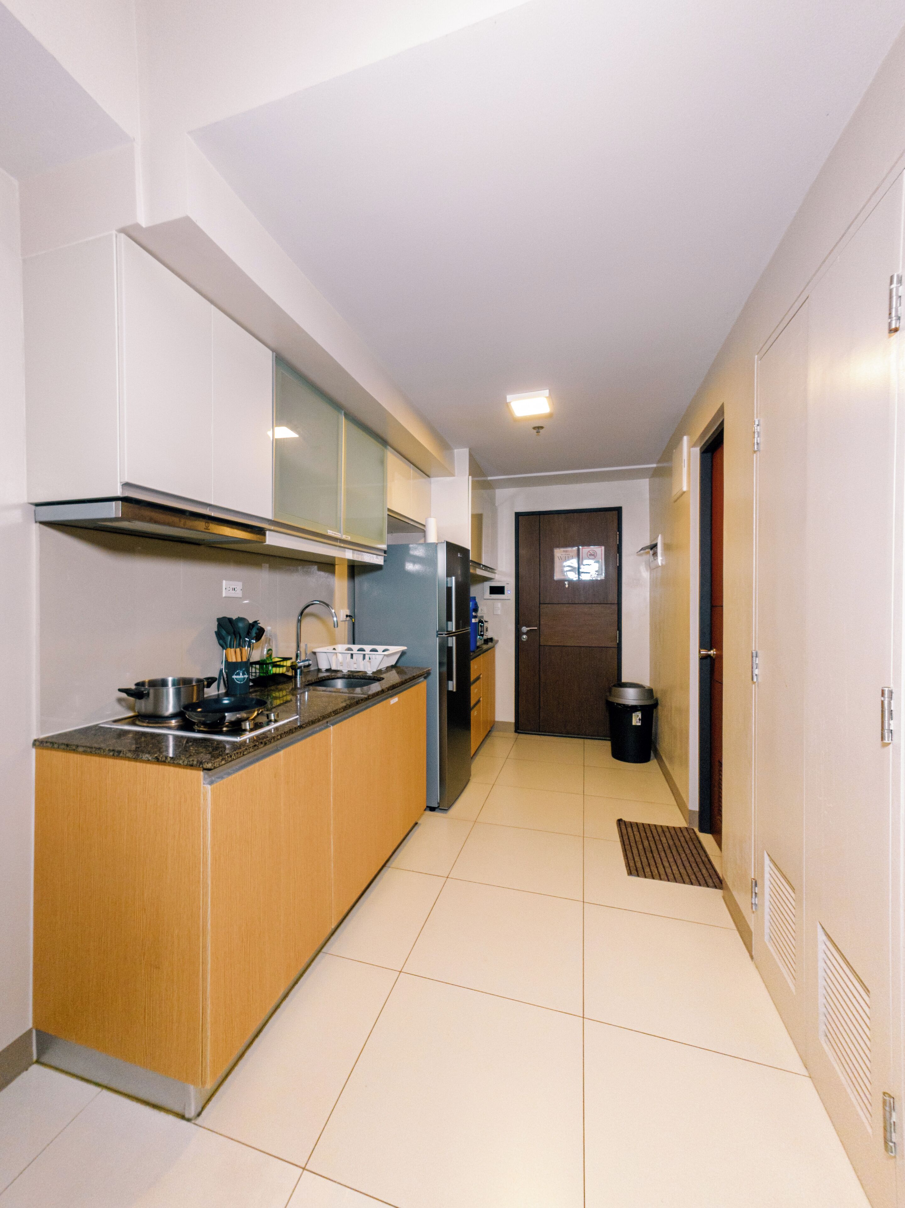 A modern kitchen with a central island, stainless steel appliances, and wooden cabinetry.