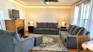 Un salon avec un canapé gris, une table basse en bois et une cheminée.