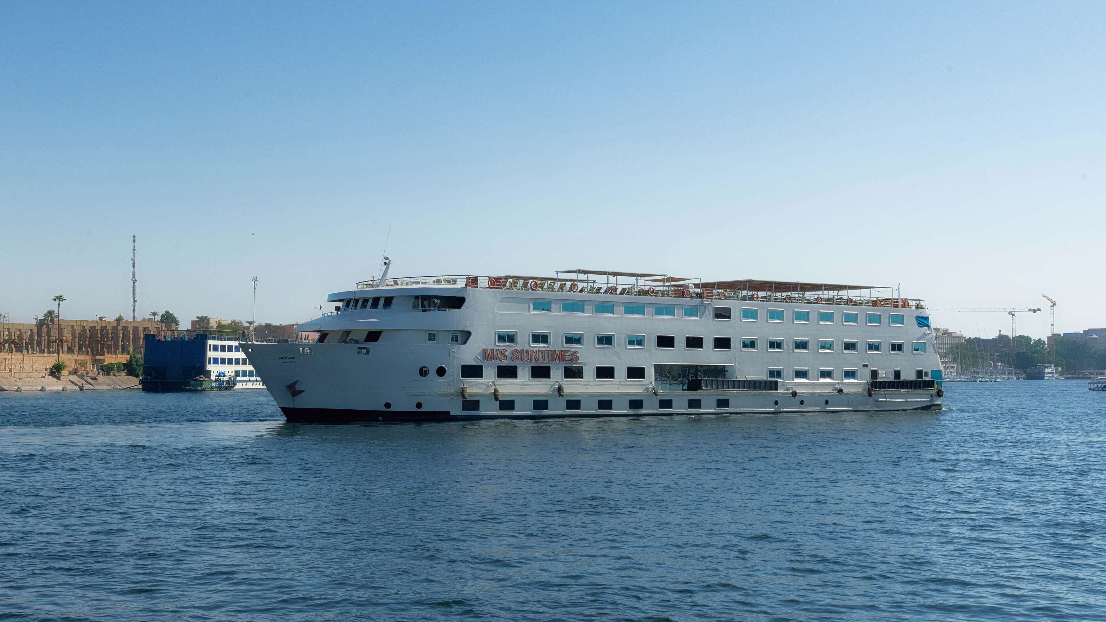 A large, multi-deck ferry with the name "M/S SUNTIMES" on its side, traveling on a body of water.
