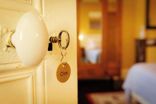 Une porte avec un trou de serrure et un porte-clés orné d’une étiquette portant l’inscription « Clos ».