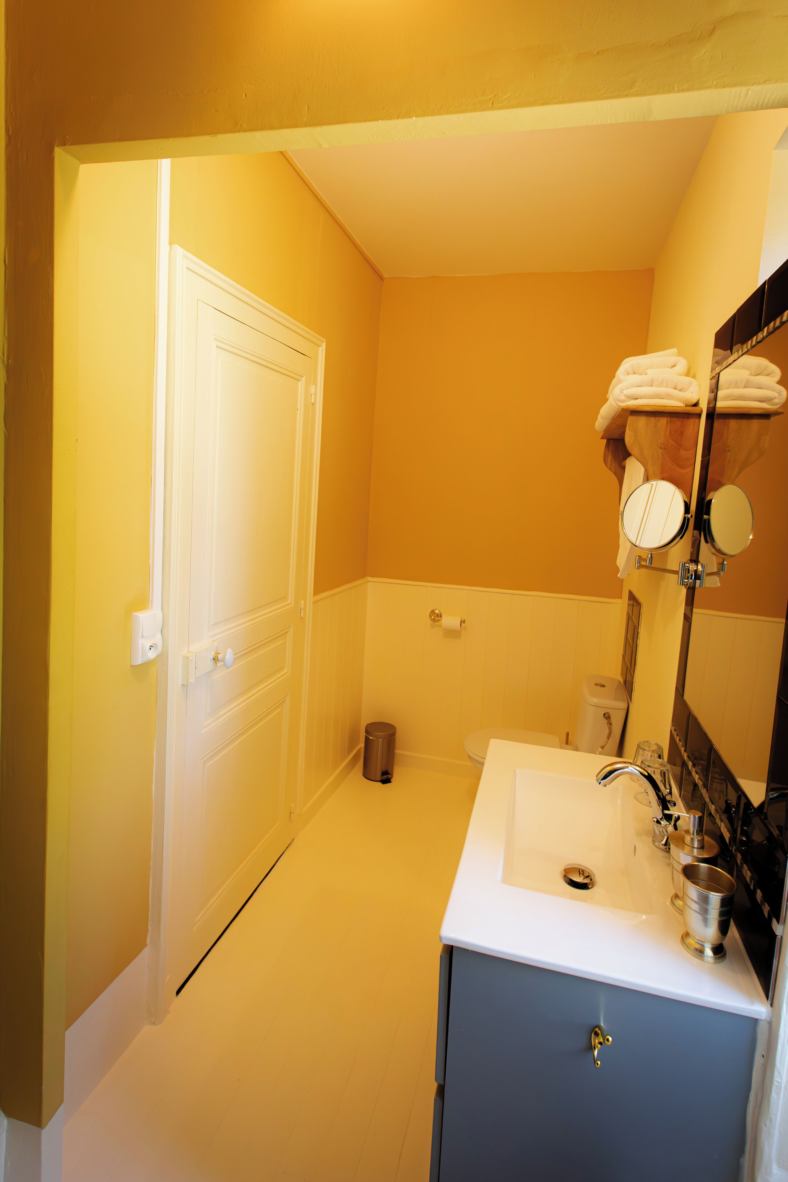 A bathroom with a white sink, a mirror, and a toilet.