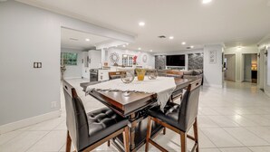 Cozinha moderna com ilha central, paredes brancas e iluminação embutida.