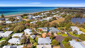 An aerial view of a residential area with houses, roads, and a beach.