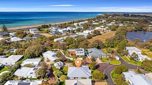 An aerial view of a residential area with houses, roads, and a beach.