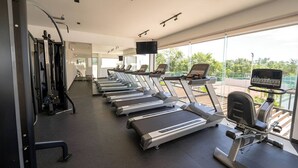 A gym with treadmills, exercise bikes, and weight machines. - Apartment for Rent in Valle Aurora 2 BDR 8 min from the Sea! (Playa del Carmen)