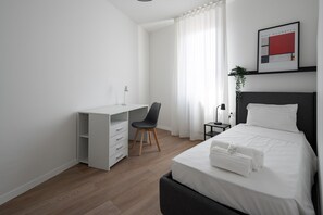 A modern hotel room with a bed, a desk, and a chair. - Carducci Modern Apartment 7 by Wonderful Italy (Mestre)