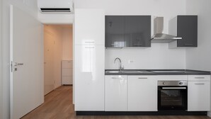 A modern kitchen with white cabinets, a stainless steel sink, and a built-in oven. - Carducci Modern Apartment 7 by Wonderful Italy (Mestre)