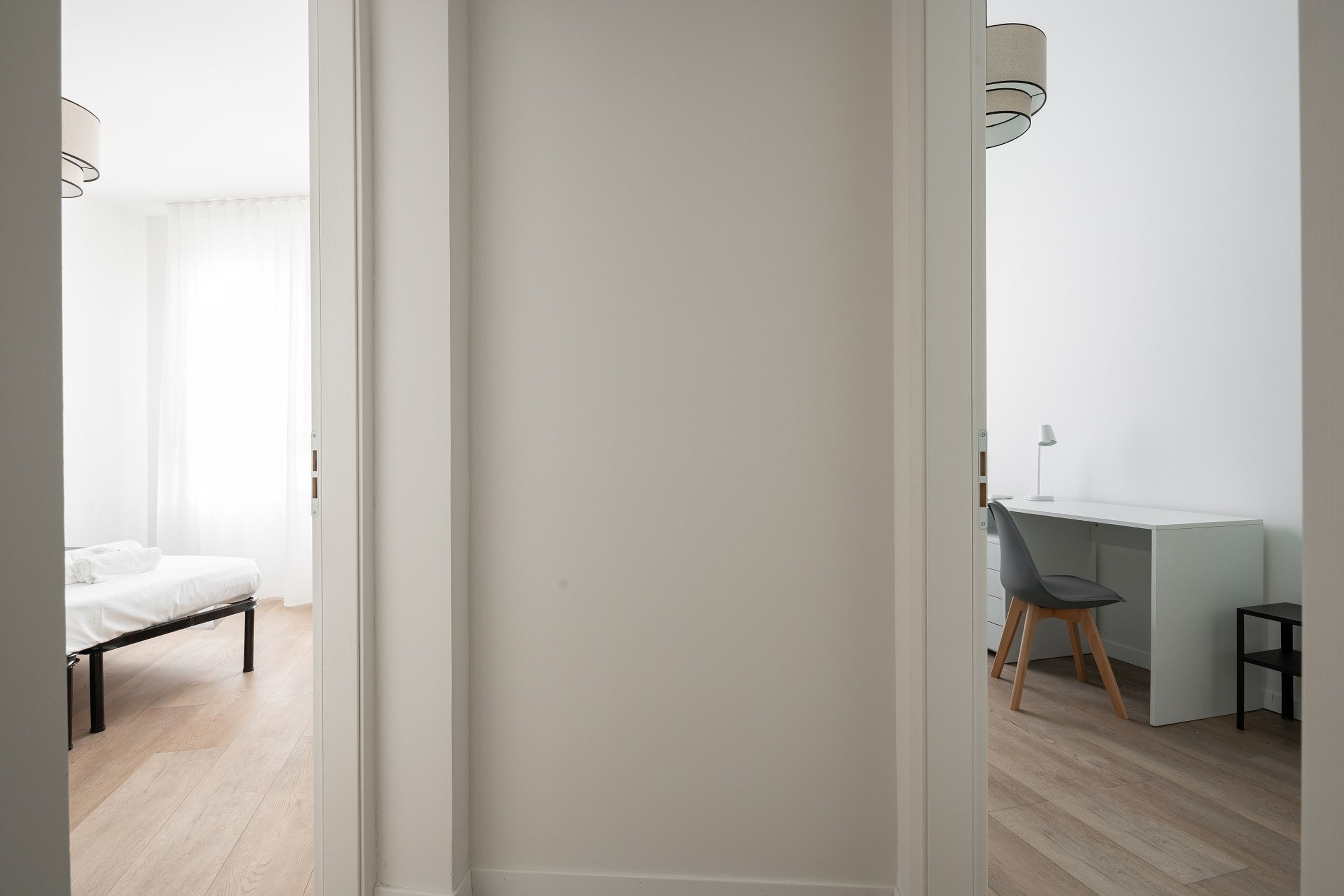 Et moderne soveværelse med seng, skrivebord og stol.