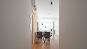 Una cocina moderna con una isla central, suelo de madera y vistas al comedor.