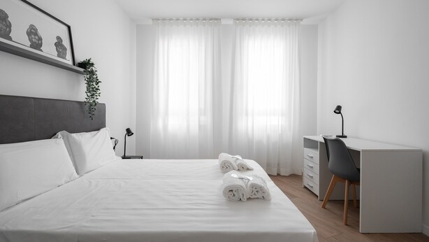 A modern bedroom with a neatly made bed, a desk, and a chair. - Carducci Modern Apartment 1 by Wonderful Italy (Mestre)