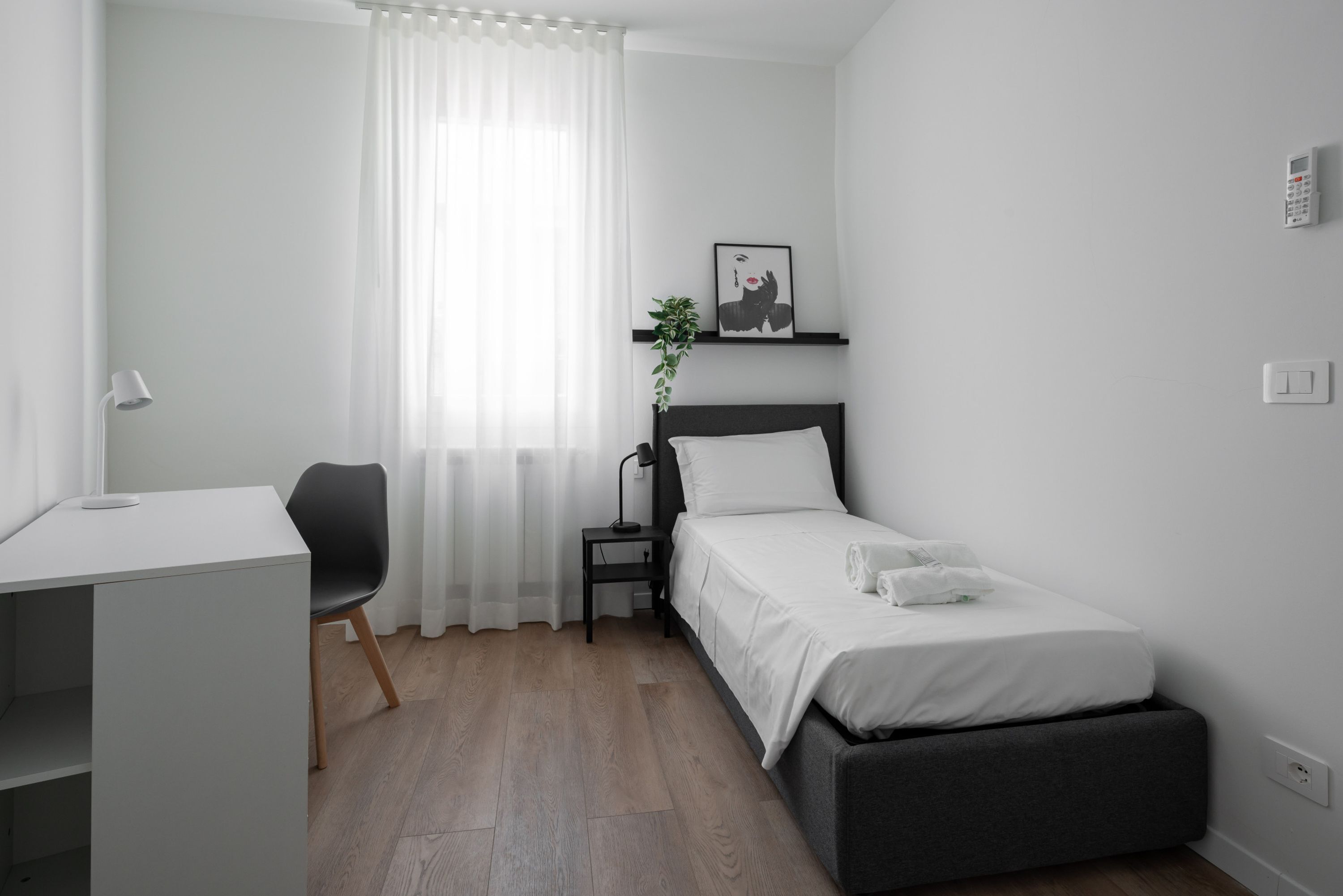 Una camera da letto moderna con un letto, una scrivania e una sedia.