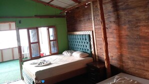 A room with a bed, a window, and a wooden ceiling.