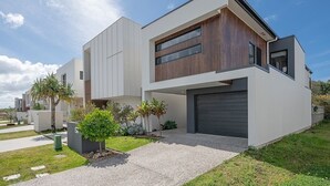 Una casa moderna de dos plantas con techo plano, ventanas amplias y garaje.