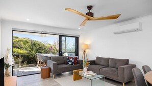 Una sala moderna con un sofá, una mesa de centro y un ventilador de techo.
