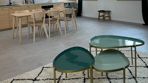 A spacious kitchen with wooden beams, a dining area with a table and chairs, and a living space with a glass coffee table. - LYON Bellecour quiet area near fabric museum - ideal for families  (Lyon)