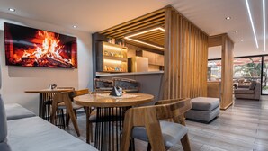 A modern dining area with a round table, wooden chairs, and a large fire-themed artwork on the wall. - Hotel Plaza doce (Pereira)