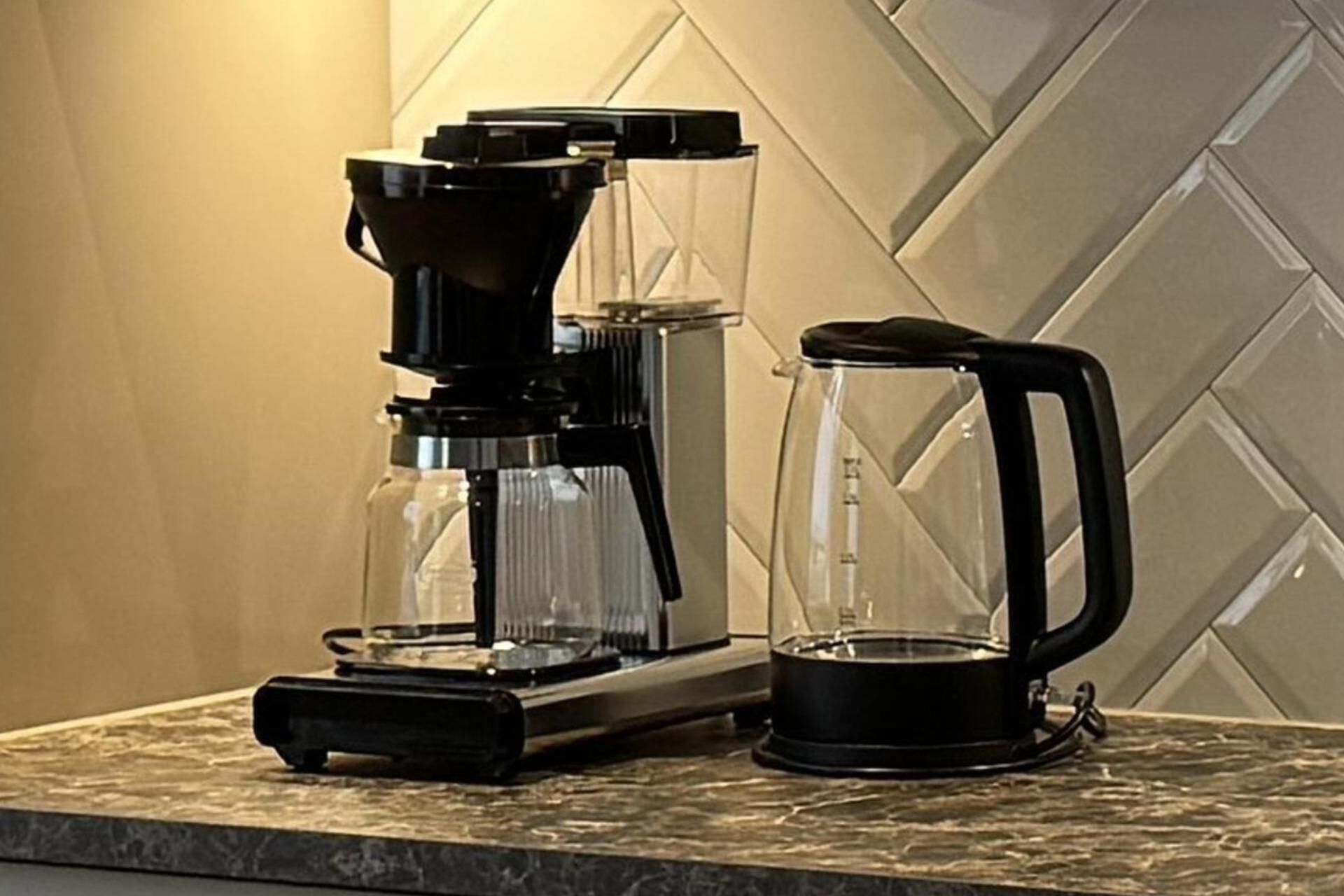 A coffee maker and a coffee pot on a kitchen counter.