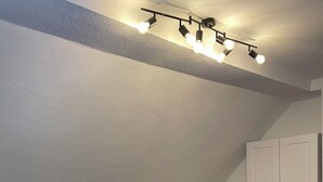 Una sala de estar moderna con un sofá modular, una mesa de centro redonda blanca y un armario blanco.