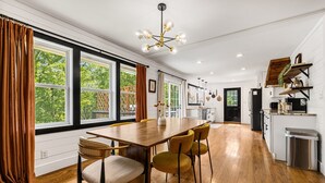 A spacious kitchen with a wooden dining table, chairs, and a modern chandelier. - Quiet Furnished 3BR Home Near Asheville - Fast WiFi, Firepit (Canton)
