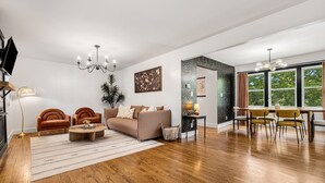 A spacious living room with a sofa, chairs, a coffee table, and a dining area with chairs and a table. - Quiet Furnished 3BR Home Near Asheville - Fast WiFi, Firepit (Canton)