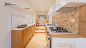 Eine moderne Küche mit Holzschränken, einem Gasherd und einer gefliesten Spritzschutzwand.