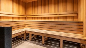 Un sauna avec des bancs en bois et des parois à lattes.