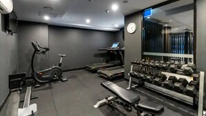 A modern gym with cardio equipment, dumbbells, and a bench. - Little Midnight 1 in the heart of town (Braddon)