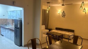A compact living space with a kitchen, dining area, and a bed. - Highriseviews/familyfriendly/neartajmahal (Agra)