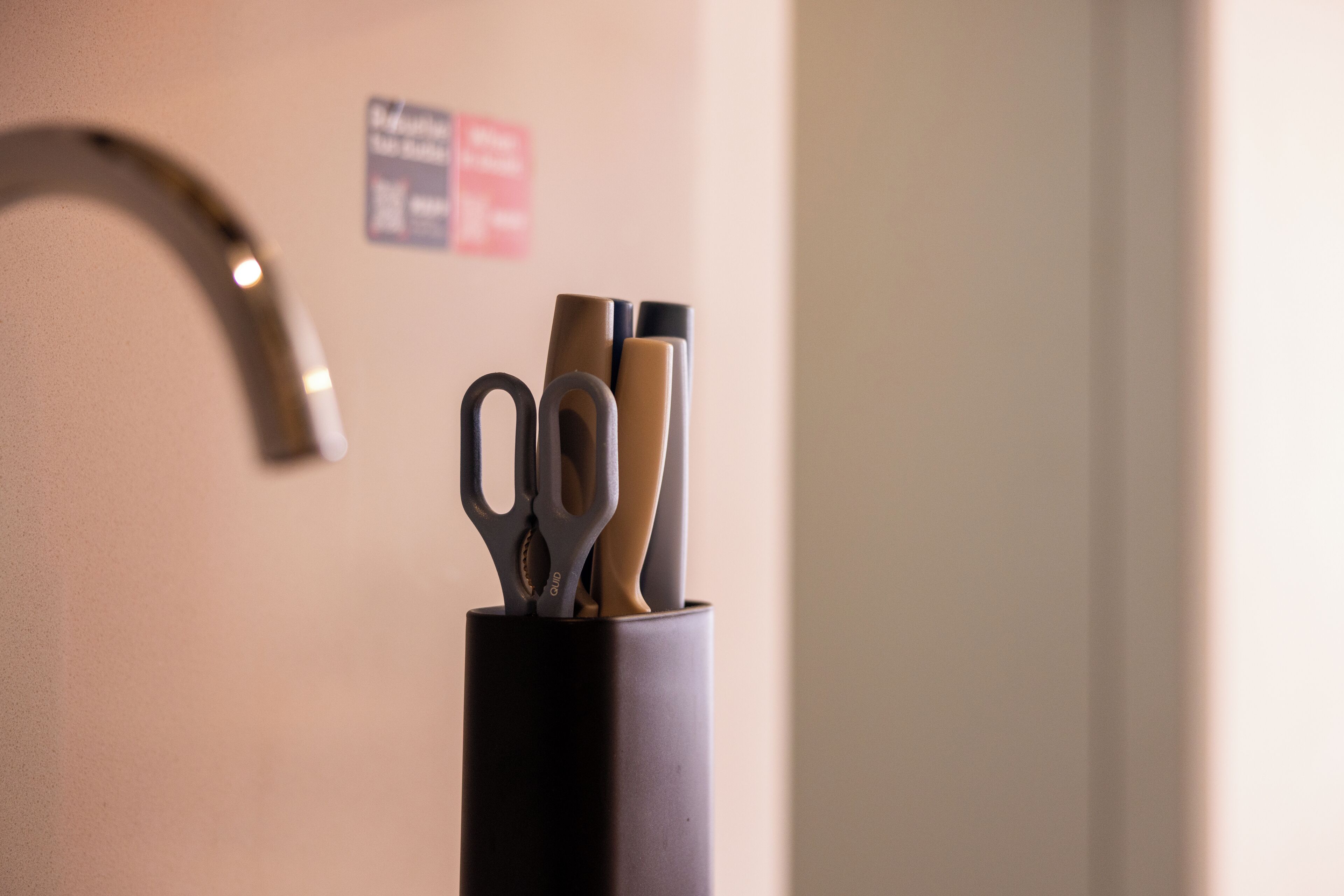 A black container with scissors and pens.