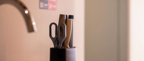 A black container with scissors and pens.