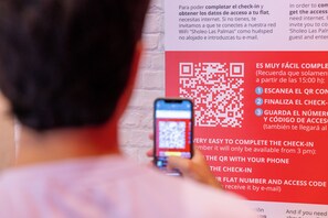 Código QR en una pared con indicaciones para el registro.