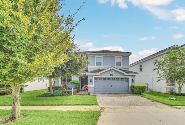 A two-story house with a garage, surrounded by well-maintained lawns and trees. - EV_1517 - 6 Bed 6 Bath Home with Screened Pool and Spillover Spa, Amazing Resort (Davenport)