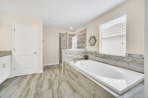 A modern bathroom with a large bathtub, a shower enclosure, and a vanity with a sink. - EV_1517 - 6 Bed 6 Bath Home with Screened Pool and Spillover Spa, Amazing Resort (Davenport)