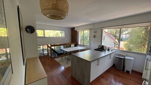 A modern kitchen with a large island, wooden flooring, and large windows offering views of the outdoors. - Cosy apartment, 5 minutes from La Baule beach (La Baule-Escoublac)