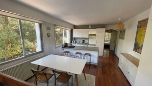 A modern kitchen with a central island, wooden chairs, and a dining table. - Cosy apartment, 5 minutes from La Baule beach (La Baule-Escoublac)