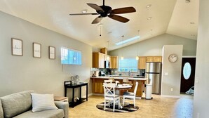 Un salon spacieux avec un canapé, une table basse et un ventilateur de plafond.