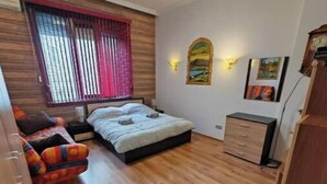 Une chambre à coucher de taille réduite, comprenant un lit, une petite table, une chaise et une commode.