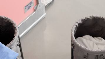 A baby changing station with a pink wall and a metal frame.