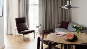 Ein modernes Wohnzimmer mit einem runden Esstisch, einer Couch und einem Sessel.